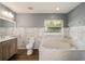 Updated bathroom with marble tile, soaking tub, and wood-look floors at 2101 Sw 3Rd St, Ocala, FL 34471