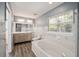 Modern bathroom with marble tile, a soaking tub, and dual vanity at 2101 Sw 3Rd St, Ocala, FL 34471