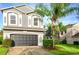 Two-story house with gray siding, a two-car garage, and palm trees in the front yard at 13412 Fox Glove St, Winter Garden, FL 34787