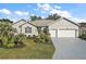 Single-story home with two-car garage, landscaped lawn, and palm trees at 24124 Robinwood St, Leesburg, FL 34748