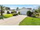 White house with gray roof and a two-car garage, landscaped yard at 586 Hartley Pl, The Villages, FL 32162