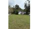 White single story house with American flags, green lawn, and white picket fence at 15518 State Road 19, Groveland, FL 34736