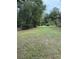 Spacious grassy yard with mature trees and a gate at 15518 State Road 19, Groveland, FL 34736