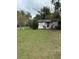 White single story house with American flags, green lawn, and white picket fence at 15518 State Road 19, Groveland, FL 34736