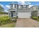 Two-story house with gray siding, shutters, and a paved driveway at 2111 Emerald Springs Dr, Apopka, FL 32712