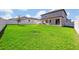 Large grassy backyard with a view of the house at 2298 Raven Ridge Rd, Minneola, FL 34715