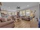Open concept living room with brown leather couches, coffee table and kitchen views at 2298 Raven Ridge Rd, Minneola, FL 34715