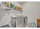 Bright laundry room with washer, dryer, and ample shelving at 2298 Raven Ridge Rd, Minneola, FL 34715