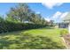 Spacious backyard with lush lawn, hedges, and a chain link fence at 3509 Indian Trl, Eustis, FL 32726