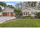 House exterior showcasing a two-car garage, landscaping, and a paved driveway at 3721 Plantation Blvd, Leesburg, FL 34748