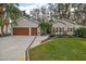 Two-car garage home with well-maintained landscaping and a paved driveway at 3721 Plantation Blvd, Leesburg, FL 34748