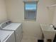 Convenient laundry room with washer, dryer, and utility sink at 5738 Leigh Ln, The Villages, FL 32163