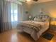 Spacious bedroom with a large bed, ample natural light, and wood-look flooring at 956 Chula Ct, The Villages, FL 32159