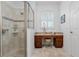 Bathroom features a vanity with drawers, a shower, and a window with shutters at 34932 Golden Tree Dr, Leesburg, FL 34788