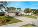 Single-story home with a two-car garage and a landscaped lawn at 34932 Golden Tree Dr, Leesburg, FL 34788