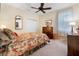Cozy bedroom with floral bedding, a dresser, and plenty of natural light at 34932 Golden Tree Dr, Leesburg, FL 34788