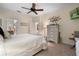 Main bedroom with ensuite access and a dresser, and a large bed at 34932 Golden Tree Dr, Leesburg, FL 34788