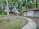 Landscaped backyard with curved walkway and outbuildings at 351 W 10Th Ave, Mount Dora, FL 32757