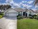 Two-story house with a three-car garage and lush lawn at 8913 Se 132Nd Loop, Summerfield, FL 34491