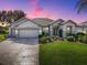 Beautiful home exterior at dusk with landscaping and driveway at 8913 Se 132Nd Loop, Summerfield, FL 34491