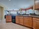 Modern kitchen with wood cabinets, granite countertops, and black appliances at 8913 Se 132Nd Loop, Summerfield, FL 34491