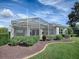 House exterior showcasing a large screened patio and landscaped yard at 8913 Se 132Nd Loop, Summerfield, FL 34491