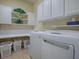Bright laundry room with washer, dryer, and ample storage at 8913 Se 132Nd Loop, Summerfield, FL 34491