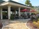 Outdoor patio area with seating and red umbrellas at 8913 Se 132Nd Loop, Summerfield, FL 34491