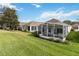 Landscaped backyard featuring a screened patio at 24317 Amberleaf Ct, Leesburg, FL 34748