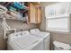 Functional laundry room with washer, dryer, and storage shelves at 24317 Amberleaf Ct, Leesburg, FL 34748