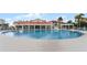 Circular community swimming pool with lounge chairs at 450 Bouchelle Dr # 301, New Smyrna Beach, FL 32169