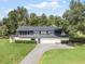 Aerial view of a mid-century modern home with a large yard at 512 E Lakeshore Dr, Clermont, FL 34711