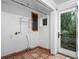 Small laundry room with tiled floor, exterior access, and shelving at 6118 Dora Dr, Mount Dora, FL 32757