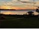 Sunset view over calm lake from grassy backyard at 6118 Dora Dr, Mount Dora, FL 32757