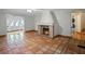 Living room with terracotta tile floors and a brick fireplace at 6118 Dora Dr, Mount Dora, FL 32757