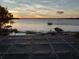 Captivating sunset view over the lake with boat and gazebo visible from balcony at 6118 Dora Dr, Mount Dora, FL 32757