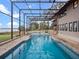 Inviting pool and spa area with a screened enclosure and lake view at 6118 Dora Dr, Mount Dora, FL 32757