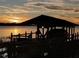 Private boat dock with covered area at sunset at 6118 Dora Dr, Mount Dora, FL 32757