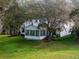 House exterior showcasing the sunroom and landscaping at 704 Alcott Ave, The Villages, FL 32162