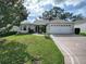 Single-story house with a two-car garage and well-manicured lawn at 8288 Se 177Th Winterthur Loop, The Villages, FL 32162