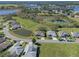 Aerial view showcasing a desirable neighborhood with houses and a pond at 21732 King Henry Ave, Leesburg, FL 34748