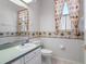 Guest bathroom with toilet, sink, and palm tree border at 21732 King Henry Ave, Leesburg, FL 34748