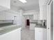 White kitchen with ample cabinet space and green countertops at 21732 King Henry Ave, Leesburg, FL 34748