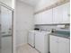 Bright laundry room with washer, dryer, cabinets, and shower at 21732 King Henry Ave, Leesburg, FL 34748