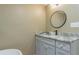Bathroom with vanity, granite countertop, and a round mirror at 2602 Cr 422, Lake Panasoffkee, FL 33538