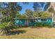 Charming teal home with a well-manicured lawn and mature trees at 2602 Cr 422, Lake Panasoffkee, FL 33538