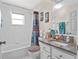 Bathroom with tub shower combo, granite vanity, and window at 5416 Essex Ct, Leesburg, FL 34748