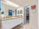 Double vanity bathroom with granite countertops and access to a walk-in closet at 5416 Essex Ct, Leesburg, FL 34748