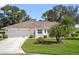 Single-story home with two-car garage and palm trees at 5416 Essex Ct, Leesburg, FL 34748