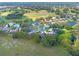 Aerial view of a residential neighborhood with houses, trees, and a golf course in the background at 5416 Essex Ct, Leesburg, FL 34748